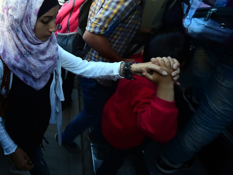 Migrants are escorted by police from Bicske train station after a local train from Budapest that was expected to cross the Hungarian-Austrian border was stopped there on September 3, 2015