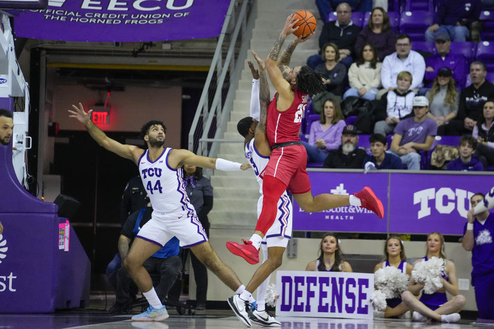 Houston guard Emanuel Sharp, right, is fouled while going up for a shot against TCU guard Avery Anderson III (3) and forward Essam Mostafa (44) during the first half of an NCAA college basketball game, Saturday, Jan. 13, 2024, in Fort Worth, Texas. (AP Photo/Julio Cortez)