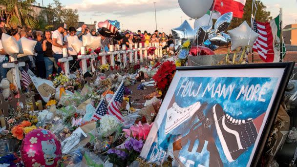 PHOTO: In this Aug. 6, 2019, file photo, people pray and pay their respects at the makeshift memorial for victims of the shooting that left a total of 22 people dead at the Cielo Vista Mall WalMart (background) in El Paso, Texas. (Mark Ralston/AFP via Getty Images, FILE)