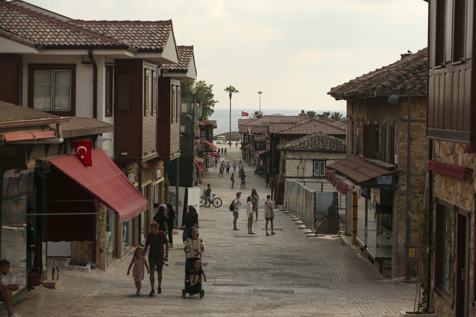 Tourists walk on the city of Antalya, southern Turkey, on Sunday, June 20, 2021. Hotels in Turkey's Antalya region, a destination beloved by holidaymakers, are preparing to finally resume operations as they expect the return of international tourists after months of setbacks caused by the pandemic that halted travel. (AP Photo/Emrah Gurel)