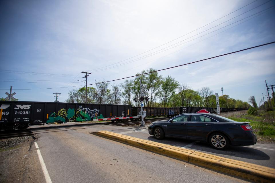 Cars wait at the Beech Road crossing as a train rolls through Thursday, May 12, 2022 in Osceola. 
