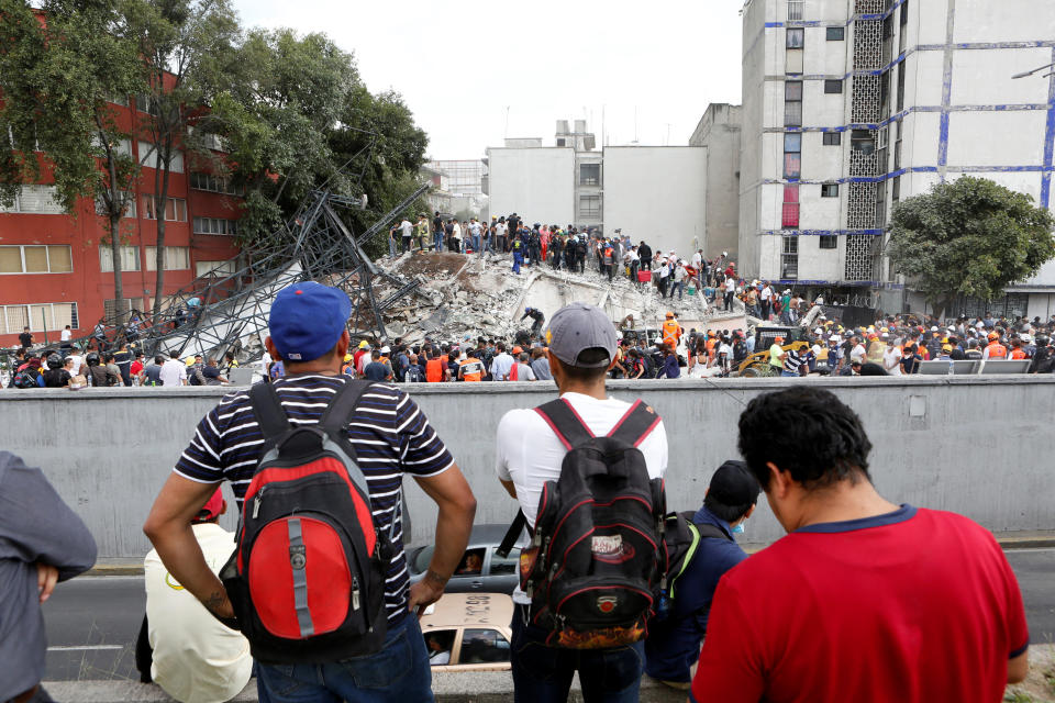 <p>Onlookers stand across from a collapsed building after an earthquake hit Mexico City, Mexico September 19, 2017. Picture taken September 19, 2017. REUTERS/Ginnette Riquelme </p>