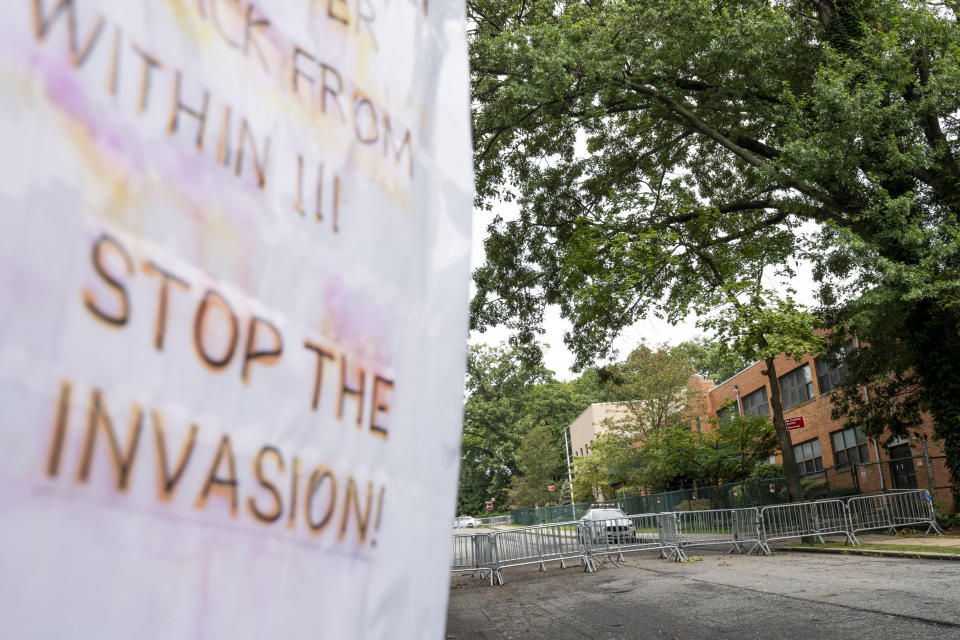 Protest signs are posted outside the former Saint John Villa Academy being repurposed as a shelter for homeless migrants, Wednesday, Sept. 13, 2023, in the Staten Island borough of New York. Scott Herkert, a New Yorker upset that the city has been housing homeless migrants on his suburban block, has set up a loudspeaker to deliver an unwelcoming message in six languages to his new neighbors: "The community wants you to go back to New York City. Immigrants are not safe here." (AP Photo/John Minchillo)