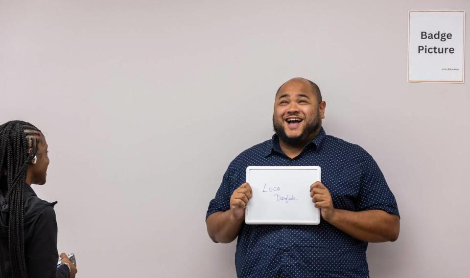 Daijah Lee, especialista en incorporación de Kelly Education, se prepara para tomar una foto de credencial a Luca Danglade, de 32 años, mientras realiza los trámites para convertirse en maestro sustituto de las Escuelas de Miami-Dade, en las oficinas de Kelly Education, el miércoles 4 de octubre de 2023, en Miami, Florida. MATIAS J. OCNER/mocner@miamiherald.com