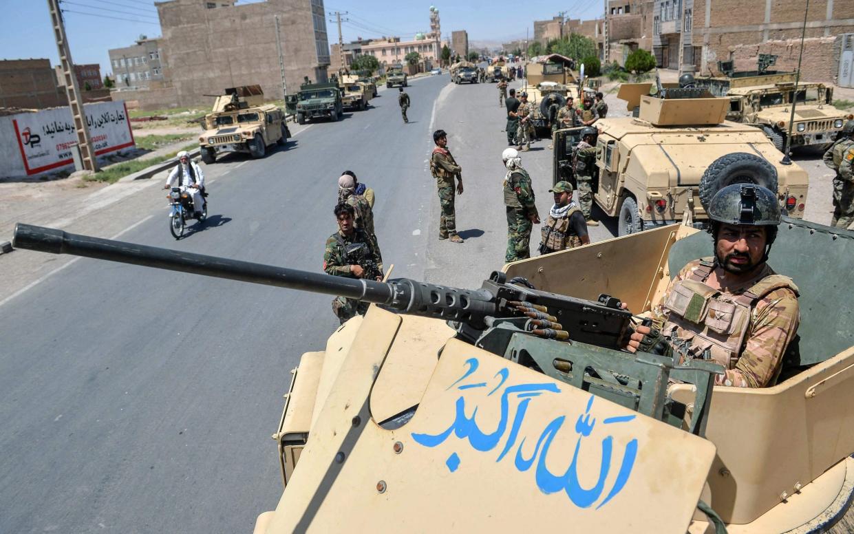 An Afghan National Army commando stands guard on top of a vehicle along the road in Enjil district of Herat province - Hoshang Hashimi/AFP 