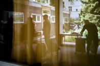 People are reflected in a window as they pack groceries in their shopping caddies at a food distribution center at the Catholic St. William Church in Berlin, Germany, Wednesday, May 31, 2023. German inflation eased to 6.1 percent in May following several months of declines, even as Europe's biggest economy registered another painful increase in food prices of nearly 15 percent. (AP Photo/Markus Schreiber)