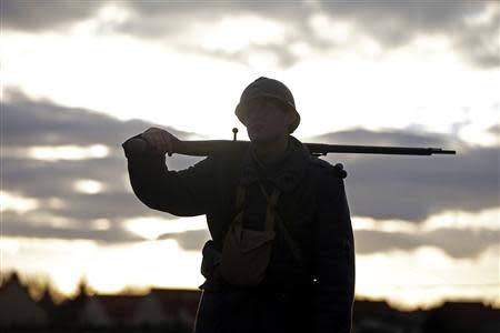 Andy, a World War One Historical Association "14-18 en Somme" member dressed in a French vintage army uniform, stands at sunset after a ceremony at the military cemetery of Lamothe-Warfusee, Northern France, in this November 10, 2013 file photo. REUTERS/Charles Platiau/Files
