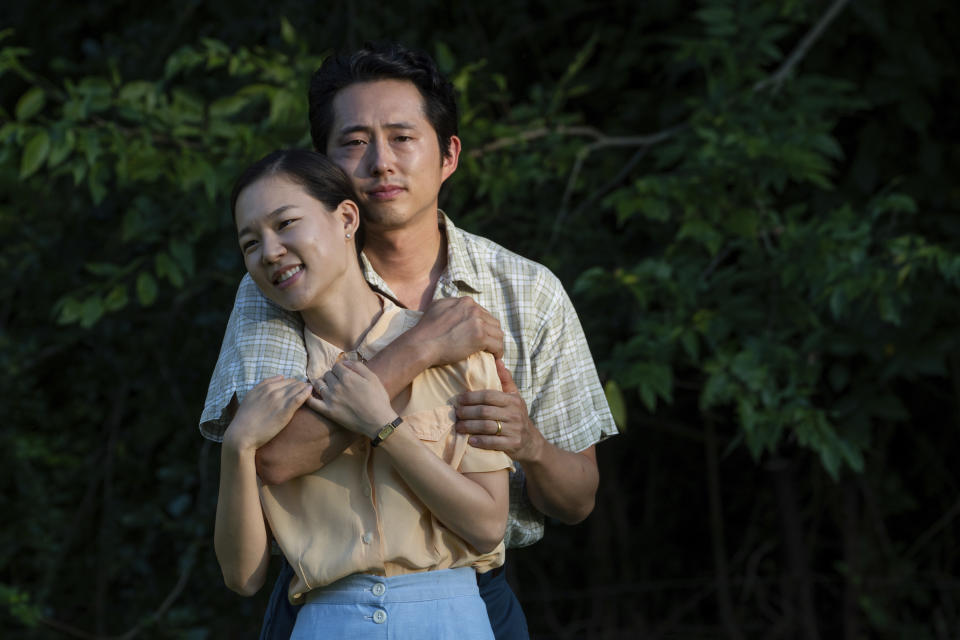 This image released by A24 shows Yeri Han, foreground, and Steven Yeun in a scene from "Minari." (Josh Ethan Johnson/A24 via AP)