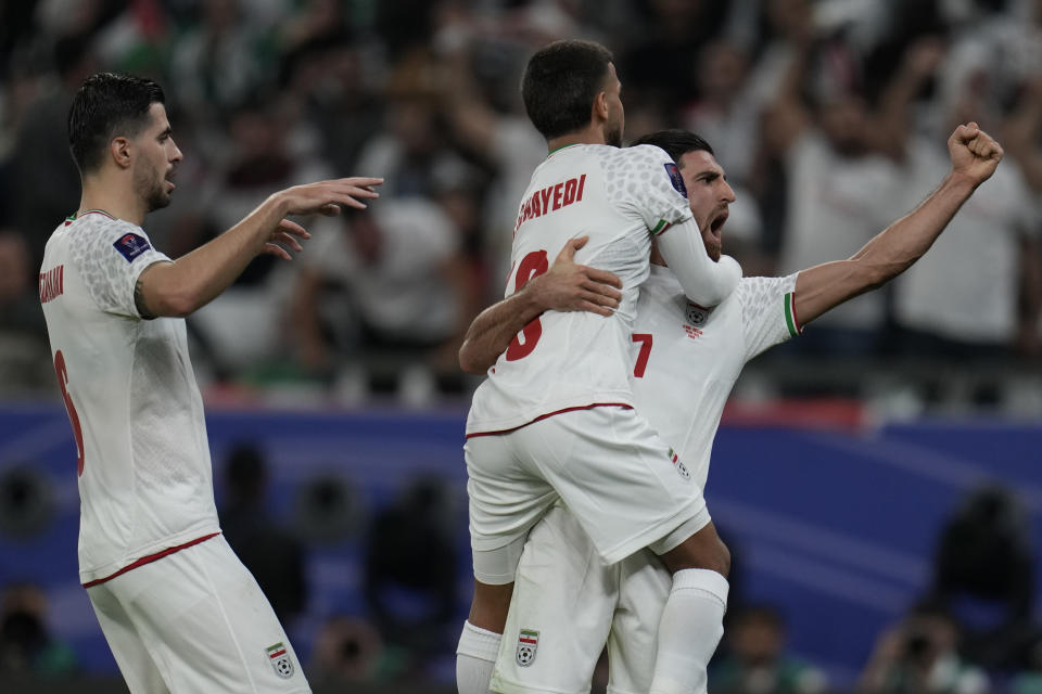 Iran's Mehdi Ghayedi, top, celebrates with teammates after scoring his side's third goal during the Asian Cup Group C soccer match between Iran and Palestine at the Education City Stadium in Al Rayyan, Qatar, Sunday, Jan. 14, 2024. (AP Photo/Aijaz Rahi)