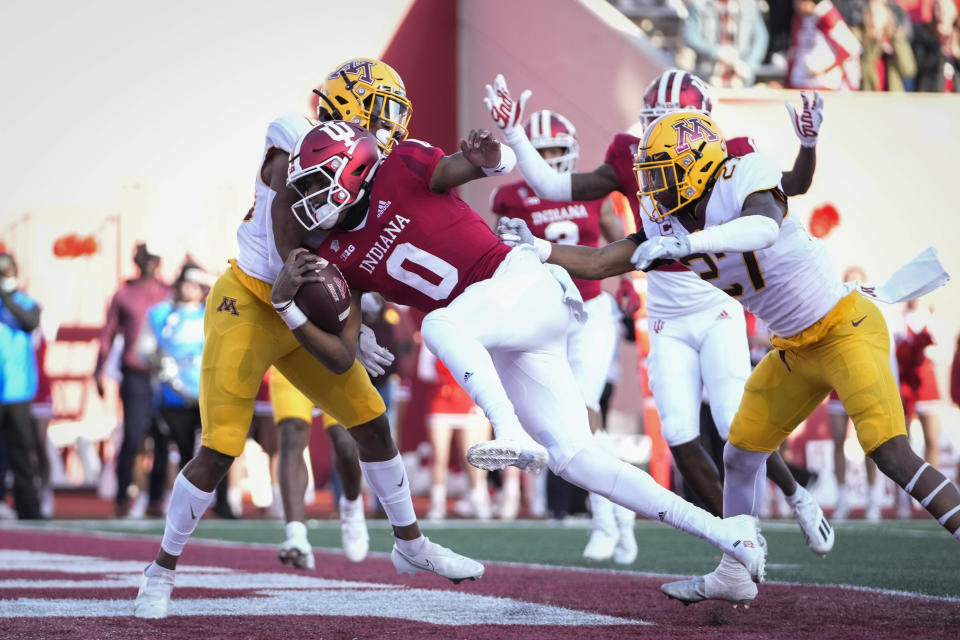 Indiana quarterback Donaven McCulley (0) scores a touchdown in front of Minnesota defensive back Tyler Nubin (27) during the first half of an NCAA college football game in Bloomington, Ind., Saturday, Nov. 20, 2021. (AP Photo/AJ Mast)