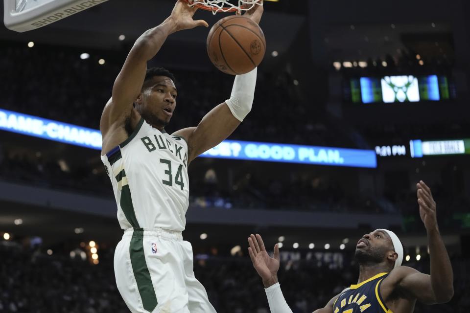 Milwaukee Bucks' Giannis Antetokounmpo dunks over Indiana Pacers' Buddy Hield during the first half of an NBA basketball game Wednesday, Dec. 13, 2023, in Milwaukee. (AP Photo/Morry Gash)