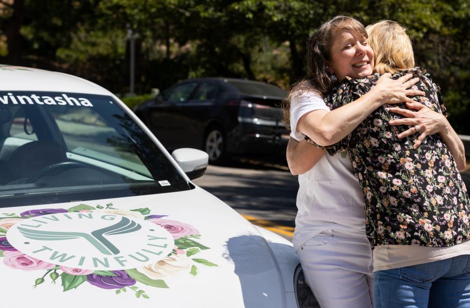 Left to right, Tasha Cram hugs Charla Haley next to the Hug Bug at the Presidential Club Condos in Salt Lake City on Saturday, July 8, 2023. After losing her twin at age 4, Cram is on a journey to give 1,000 healing hugs to twins across the U.S. | Megan Nielsen, Deseret News