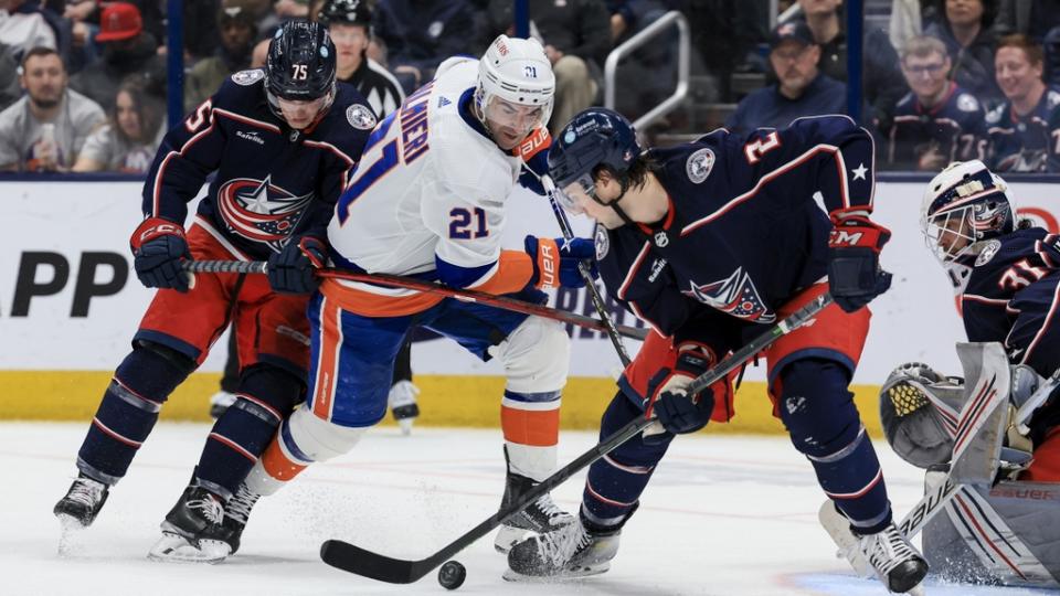 New York Islanders center Kyle Palmieri (21) battles for the loose puck against Columbus Blue Jackets defenseman Tim Berni (75) and defenseman Andrew Peeke (2) in the second period.