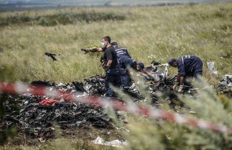 Ukrainian emergency service workers collect bodies of victims at the crash site of Malaysia's flight MH17 in east Ukraine on July 20, 2014