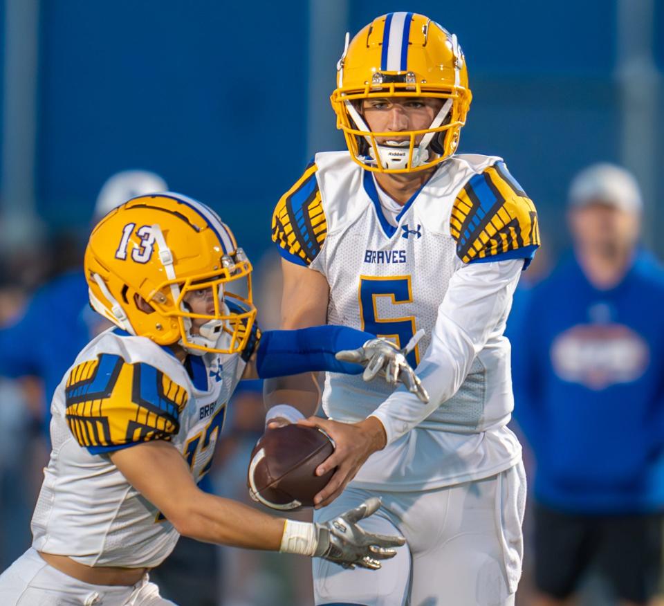 Olentangy senior quarterback Ethan Grunkemeyer hands the ball off to Riley Clarkson during a game against Olentangy Berlin on Sept. 22.