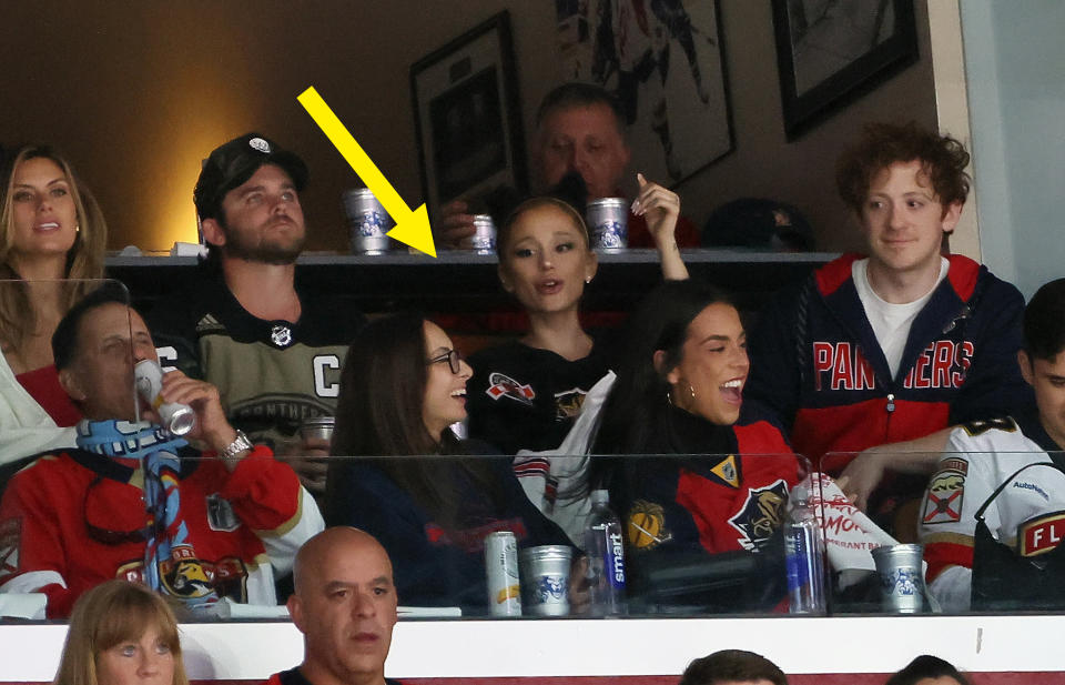 Ariana Grande and Ethan Slater with friends watching a hockey game in a private suite. They appear to be enjoying the game