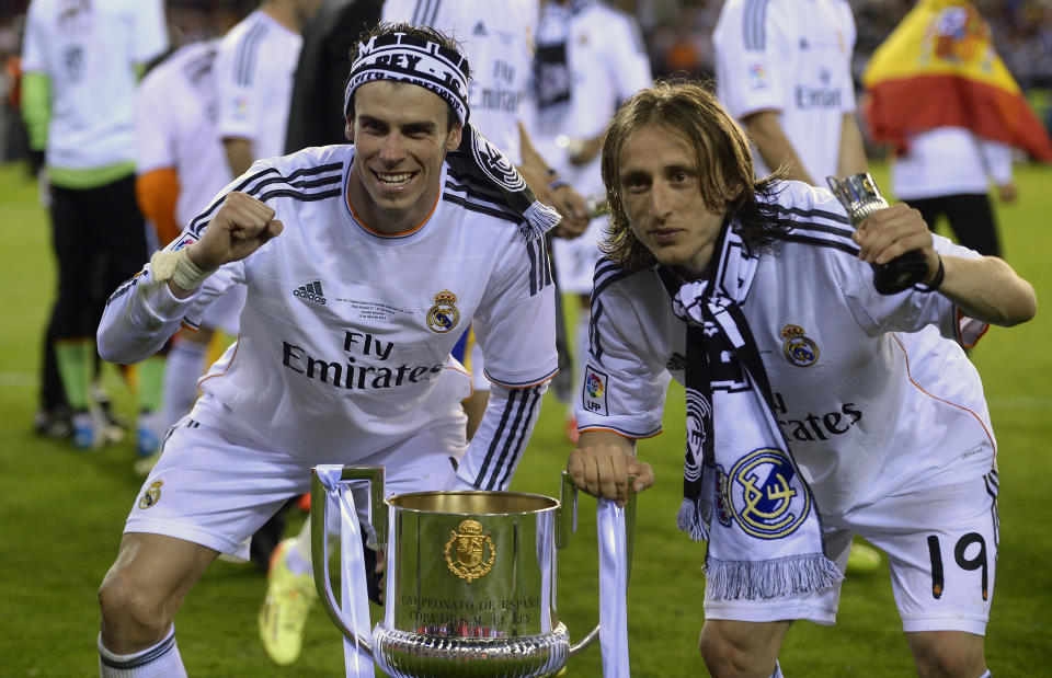 FILE - Real's Gareth Bale, left, and Luka Modric celebrate with the trophy at the end of the final of the Copa del Rey between FC Barcelona and Real Madrid at the Mestalla stadium in Valencia, Spain, Wednesday, April 16, 2014. Real defeated Barcelona 2-1. (AP Photo/Manu Fernandez, File)