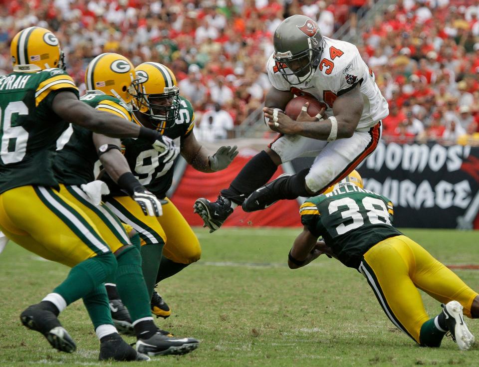 Tampa Bay Buccaneers running back Earnest Graham (34) leaps from the Green Bay Packers defense, including Tramon Williams (38), Johnny Jolly (97) and Charlie Peprah (26) during the second half of their game on Sept. 28, 2008, in Tampa. Tampa Bay won 30-21.