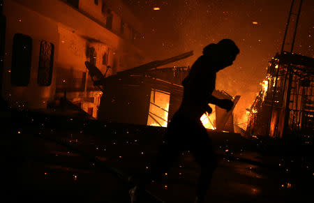 A resident is seen during a fire at Educando neighbourhood, a branch of the Rio Negro, a tributary to the Amazon river, in the city of Manaus, Brazil December 17, 2018. REUTERS/Bruno Kelly