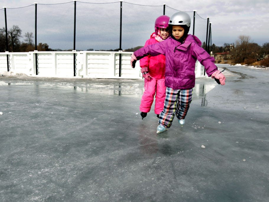 Two children ice skating.