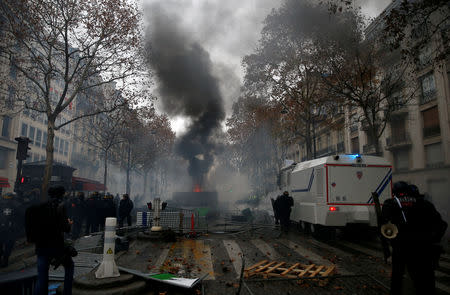 FILE PHOTO: French riot police stand guard near a barricade during clashes with protesters wearing yellow vests, a symbol of a French drivers' protest against higher diesel taxes, at the Place de l'Etoile in Paris, France, December 1, 2018. REUTERS/Stephane Mahe/File Photo