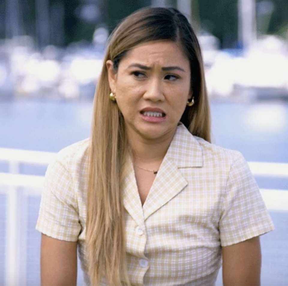 Woman in plaid shirt making a confused facial expression outdoors