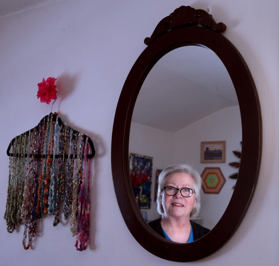 Kristine Kadlec's reflection is seen in a mirror she found while Dumpster diving. The piece was in mint condition. With a limited budget and an interest in keeping things out of landfills, Kadlec has furnished her one bedroom apartment in Milwaukee with pieces she hauled home along with items from family members.