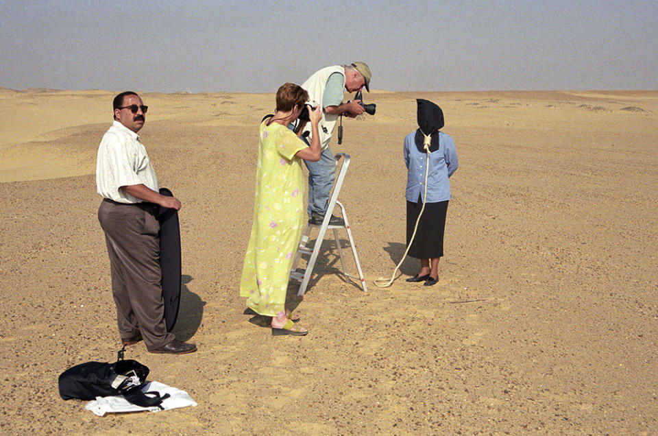 Moustafa Bassiouni, left, assists Pulitzer-prize winning photographer Eddie Adams and writer Kerri Kennedy Cuomo, working on a book about human rights heroes around the world, in Egypt circa 1999. Bassiouni, an intrepid photo assistant and driver for The Associated Press’ Cairo bureau, has died at age 64. His family said he died in a Cairo hospital on Saturday, June 10, 2023, after experiencing a heart attack. (AP Photo/Norbert Schiller)