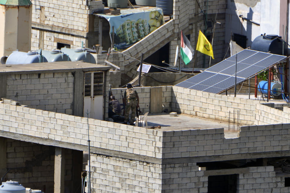 Fighters from the Palestinian Fatah group take position during clashes with Islamist militants in the Palestinian refugee camp of Ein el-Hilweh near the southern port city of Sidon, Lebanon, Sunday, Sept. 10, 2023. Islamist factions in Lebanon's largest Palestinian refugee camp said Sunday they will abide by a cease-fire after three days of clashes killed at least five people and left hundreds of families displaced. (AP Photo/Bilal Hussein)