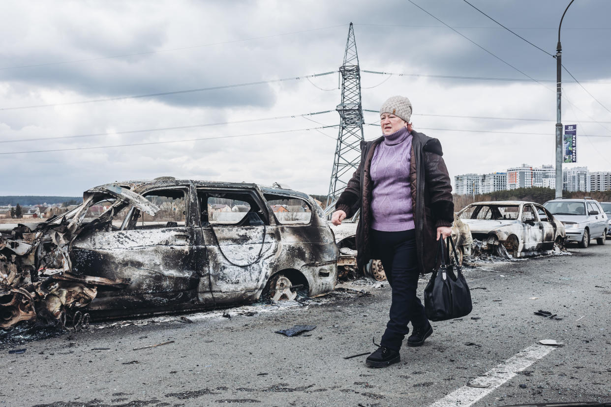 IRPIN, UKRAINE - MARCH 07: A woman walks in front of burned cars on a bridge in Irpin, on March 7, 2022, in Irpin, Ukraine. The Ukrainian army is resisting for the moment the heavy Russian siege in some of its cities, such as Irpin and Kiev, where fighting is intensifying. The United Nations estimates that the number of Ukrainian refugees could reach 1.5 million. (Photo By Diego Herrera/Europa Press via Getty Images)