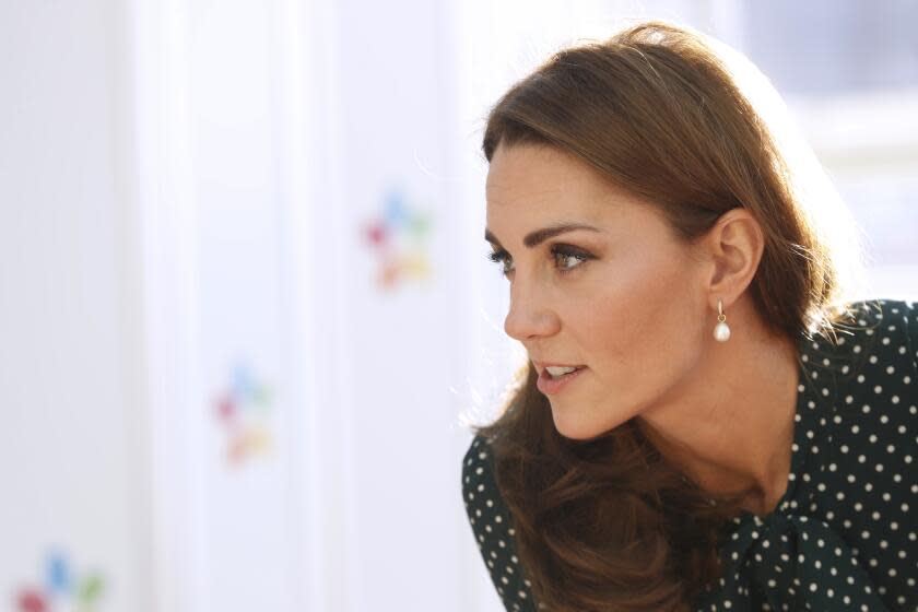 A side view of Britain's Catherine, who is waring a polka dot top and pearl earring