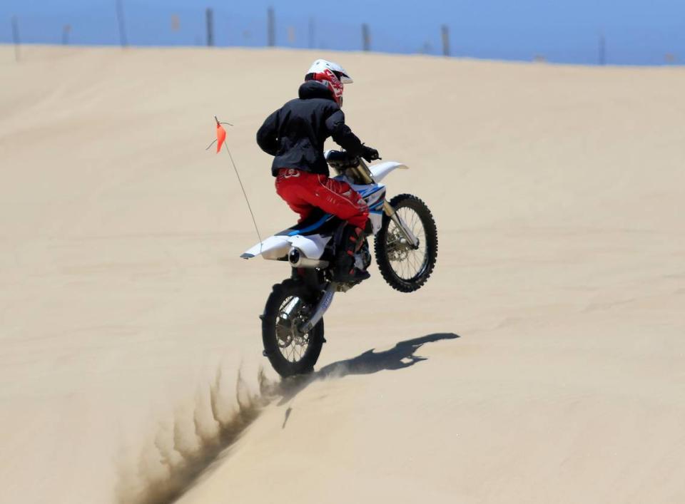 A dirt bike rider pops a wheelie at the Oceano Dunes on Saturday, June 29, 2019.