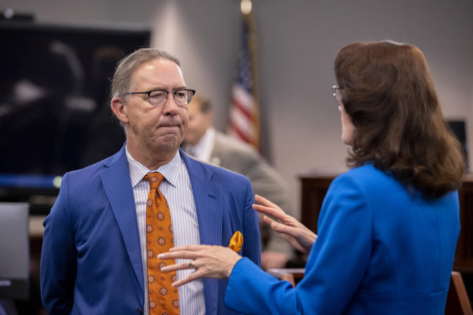 Defense attorney Franklin Hogue, left, and prosecutor Linda Dunikoski, right, talk before the trial of Greg McMichael and his son, Travis McMichael, and a neighbor, William "Roddie" Bryan starts in the Glynn County Courthouse, Tuesday, Nov. 9, 2021, in Brunswick, Ga. Three white men are on trial for murder and other crimes in the slaying of Ahmaud Arbery, who was chased and shot Feb. 23, 2020, after he was spotted running in a neighborhood just outside the port city of Brunswick. (AP Photo/Stephen B. Morton, Pool)