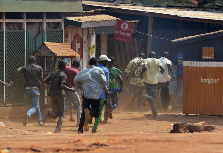 Men run during a protest against the French "Sangaris" intervention in the Galabadia neighbourhood of Bangui on December 22, 2013