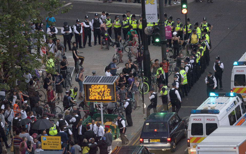 Police surround part of a group of protesting cyclists who tried to block traffic with a mass cycle ride on a road outside the Olympic Park during the Opening Ceremony of the 2012 Summer Olympics, Friday, July 27, 2012, in London. (AP Photo/Ben Curtis)