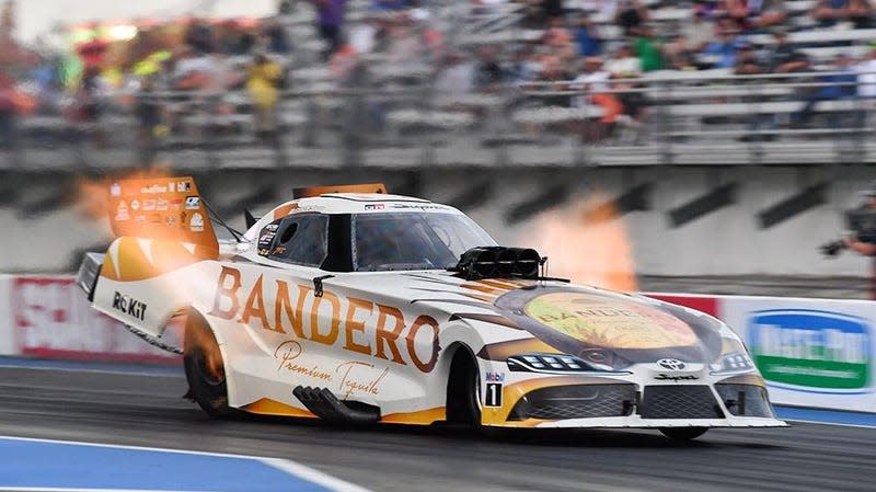 NHRA Funny Car racer Alexis DeJoria's car shoots flames as it races down the track