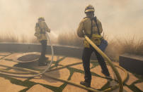 Firefighters protect a home from a wildfire in the Pacific Palisades area of Los Angeles, Monday, Oct. 21, 2019. (AP Photo/Christian Monterrosa)