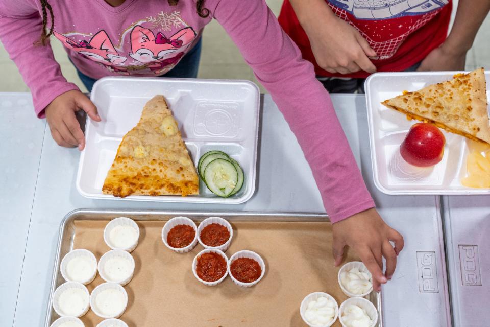 Students grab condiments while checking out during a lunch period at Wilcox Elementary School in Holt on Wednesday, Nov. 8, 2023. Students at the school are supplied with free lunches as part of the Michigan School Meals project, which makes breakfast and lunch free for all students in public schools.