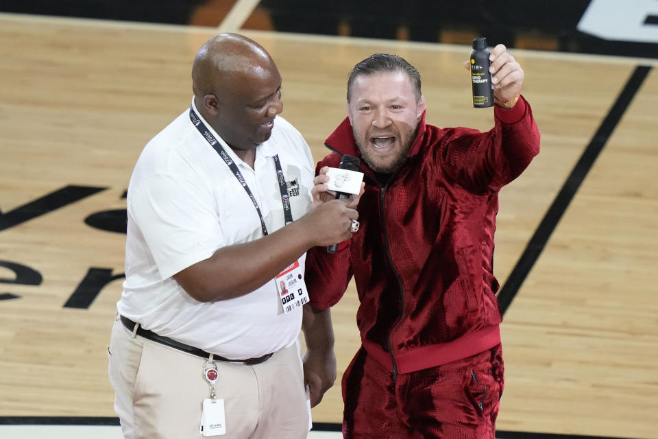 Former UFC champion Conor McGregor promotes a pain-relief spray during a break in Game 4 of the basketball NBA Finals between the Miami Heat and the Denver Nuggets, Friday, June 9, 2023, in Miami. (AP Photo/Lynne Sladky)