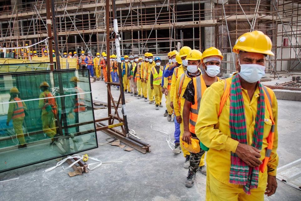 Workers at a Doha construction site lining up to get into buses to head to their sleeping quarters to rest during the mid-day heat, until the afternoon work started up again.<span class="copyright">Ed Kashi—VII for TIME</span>