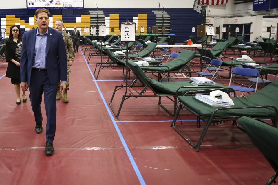 New Hampshire Gov. Chris Sununu, tours a makeshift medical facility on a basketball court in a gymnasium at Southern New Hampshire University in Manchester, N.H. (AP Photo/Charles Krupa)