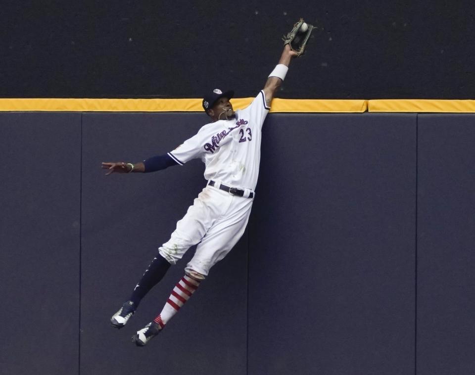 FILE - In this July 4, 2018, file photo, Milwaukee Brewers' Keon Broxton makes a leaping catch at the wall on a ball hit by Minnesota Twins' Brian Dozier during the ninth inning of a baseball game in Milwaukee. Everyone has seen an outfielder receive a tip of the cap or a jubilant fist bump from a pitcher after a home run robbery. This is a story about what happens after they leave the field. (AP Photo/Morry Gash, File)