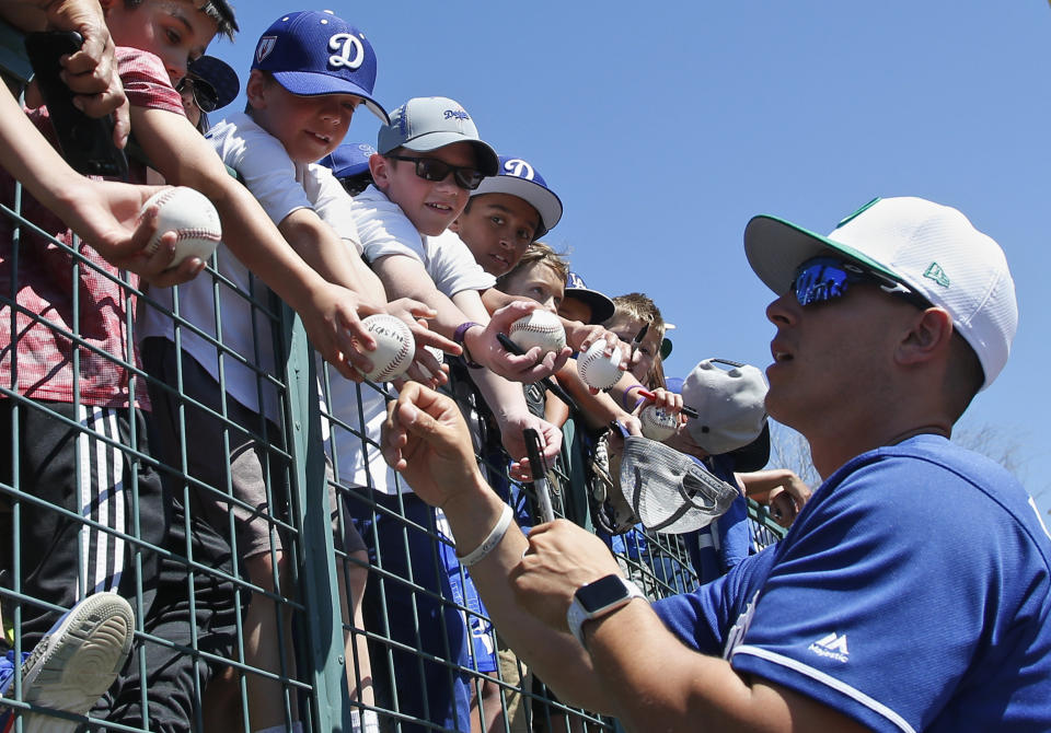 Los Angeles Dodgers' Julio Urias signs autographs for young fans before a spring training baseball game between the Milwaukee Brewers and the Los Angeles Dodgers on Sunday, March 17, 2019, in Glendale, Ariz. (AP Photo/Sue Ogrocki)