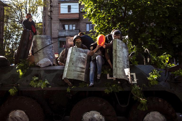 Pro-Russian activists sit on a Ukrainian tank on May 10, 2014 in Mariupol, southeastern Ukraine