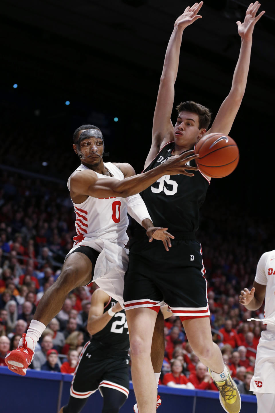 Dayton forward Zimi Nwokeji (0) passes the ball in frront of Davidson forward Luka Brajkovic (35) during the first half of an NCAA college basketball game Friday, Feb. 28, 2020, in Dayton, Ohio. (AP Photo/Gary Landers)