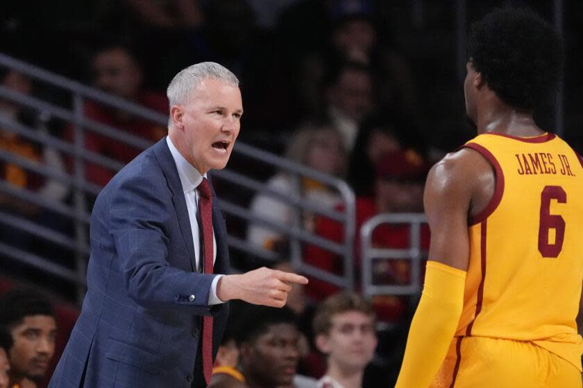 Southern California head coach Andy Enfield, left, talks with guard Bronny James during the first half of an NCAA college basketball game against Utah Thursday, Feb. 15, 2024, in Los Angeles. (AP Photo/Mark J. Terrill)