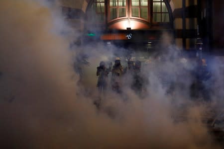 Journalists work amid tear gas during a protest against police violence in Hong Kong