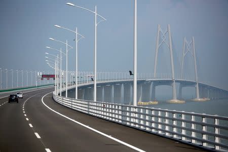 FILE PHOTO: Cars drive on a section of the Hong Kong-Zhuhai-Macau Bridge, to be opened in Zhuhai, China March 28, 2018. REUTERS/Bobby Yip/File Photo