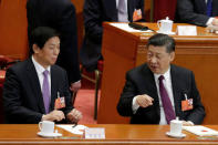 Chinese President Xi Jinping (R) talks to Chinese Politburo Standing Committee member Li Zhanshua, as delegates vote at the fifth plenary session of the National People's Congress (NPC) at the Great Hall of the People in Beijing, China March 17, 2018. REUTERS/Jason Lee