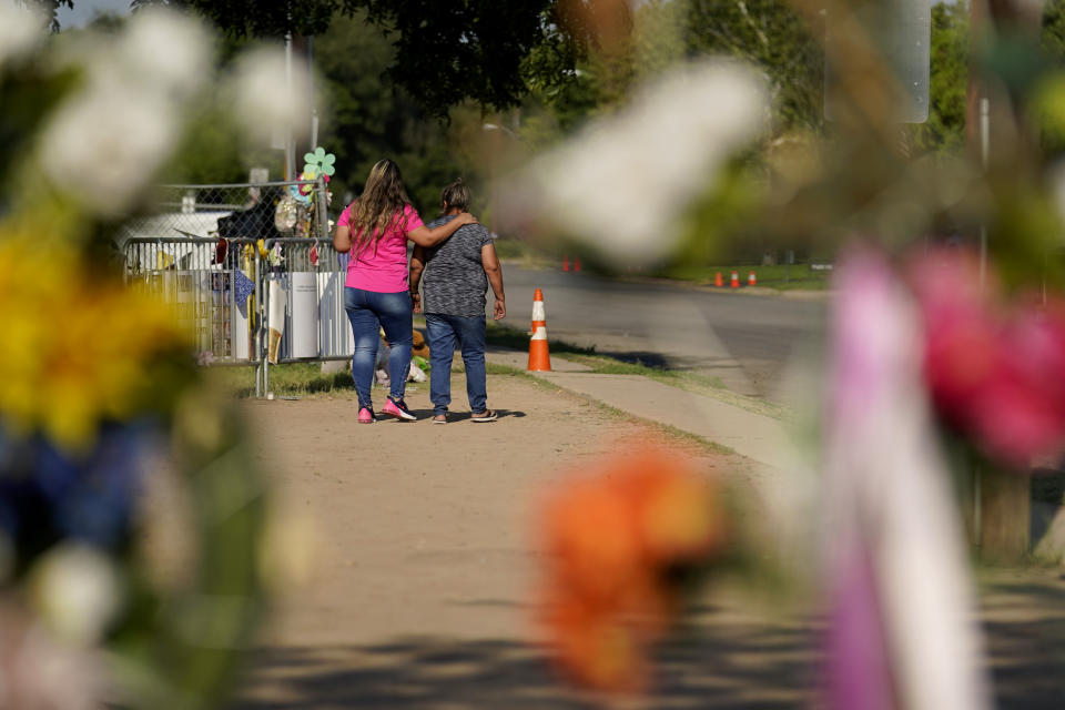 Mourners visit a make-shift memorial honoring the school shooting victims at Robb Elementary, Monday, July 11, 2022, in Uvalde, Texas. Students who survived the May 24 shooting at an elementary school in Uvalde, Texas are spending the summer grappling with post-traumatic stress disorder. Meanwhile, parents find themselves unable to help them, worried the tragedy at Robb Elementary struck a largely Hispanic town as Latinos continue to face disparities to access mental health care. (AP Photo/Eric Gay)